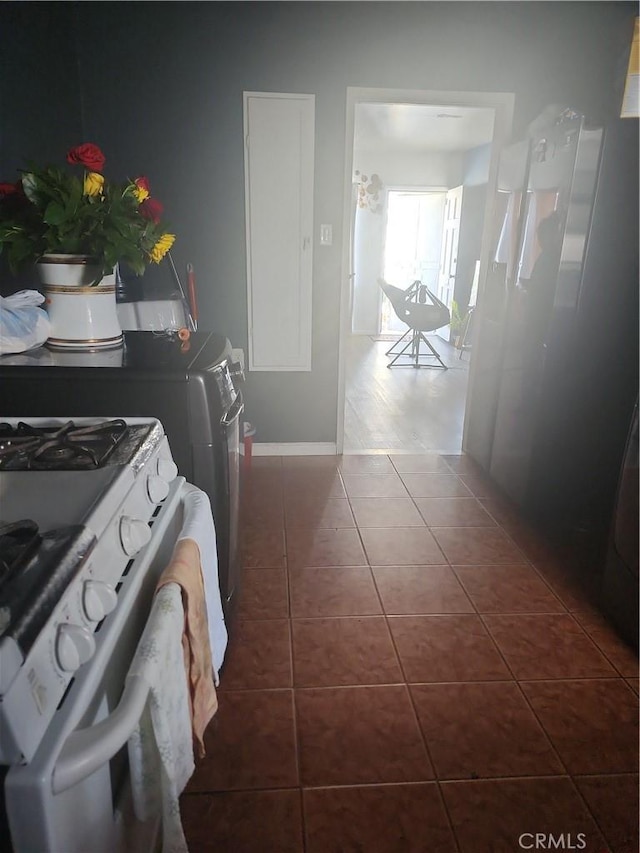 laundry area with dark tile patterned flooring