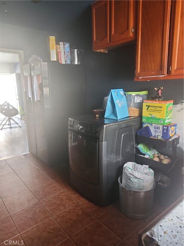 laundry room with dark tile patterned flooring and washer / clothes dryer