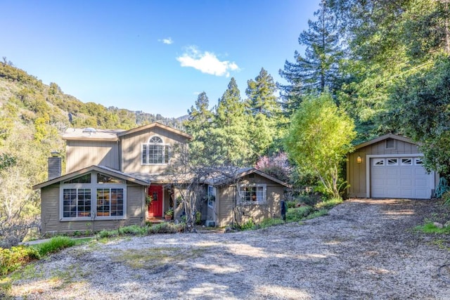 view of front facade with an outbuilding, a mountain view, and a garage