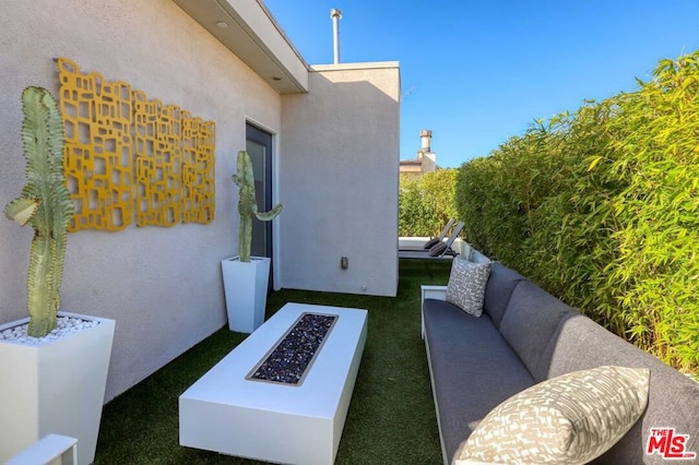 view of patio with an outdoor living space with a fire pit