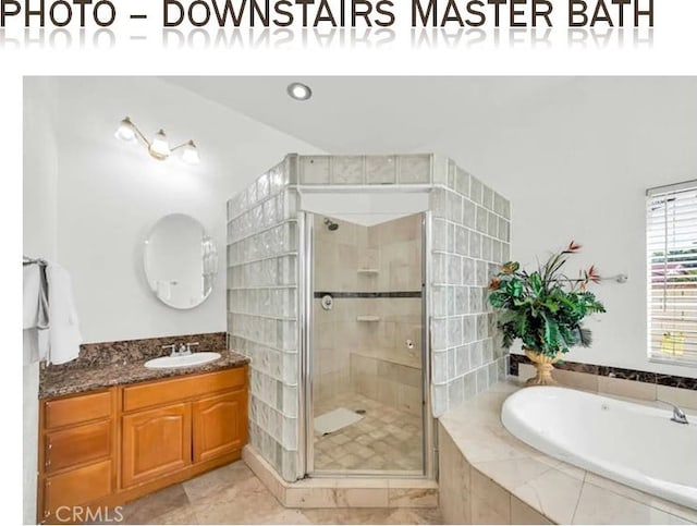 full bathroom with a garden tub, a shower stall, and vanity