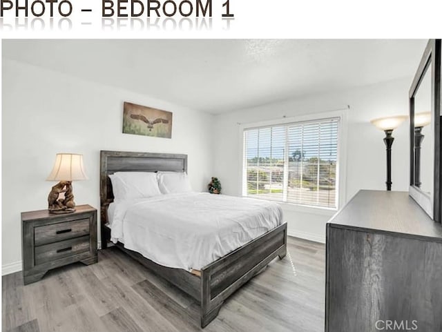 bedroom featuring baseboards and wood finished floors