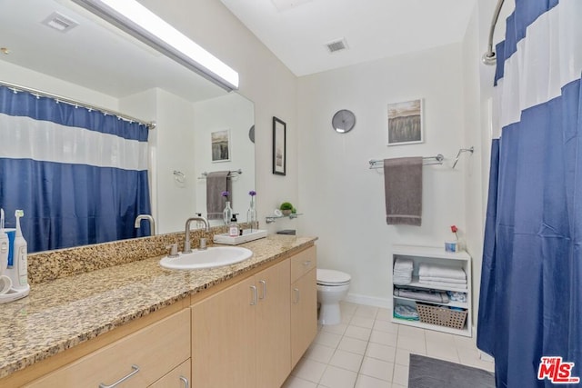 bathroom featuring tile patterned floors, vanity, and toilet