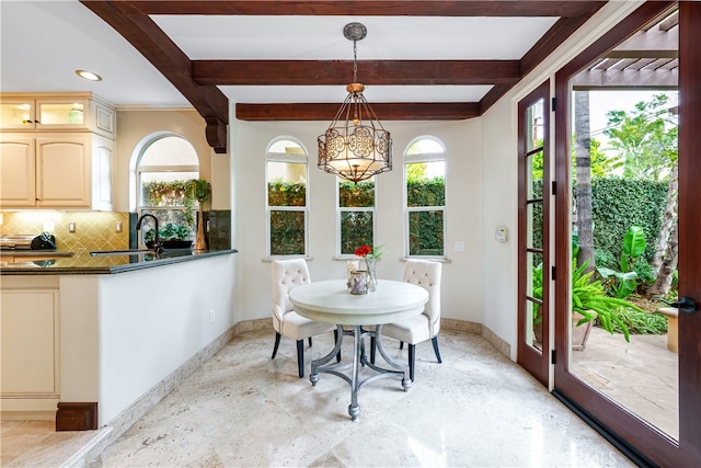 dining area with beam ceiling and sink