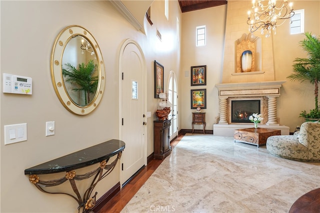 foyer entrance with a chandelier, wood-type flooring, and a wealth of natural light