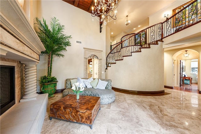 interior space with a high ceiling, ornate columns, and an inviting chandelier