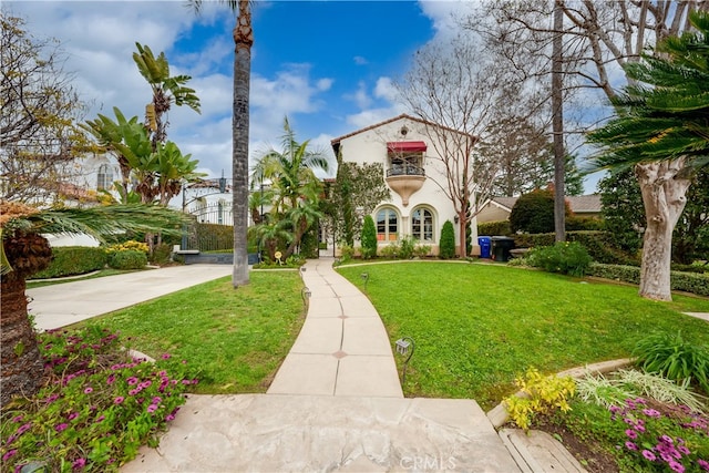 view of front of property with a balcony and a front yard