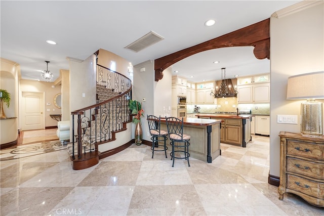 kitchen with a kitchen island, a breakfast bar area, pendant lighting, custom exhaust hood, and appliances with stainless steel finishes