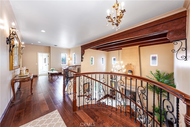 hall featuring ornamental molding, an inviting chandelier, and dark hardwood / wood-style flooring