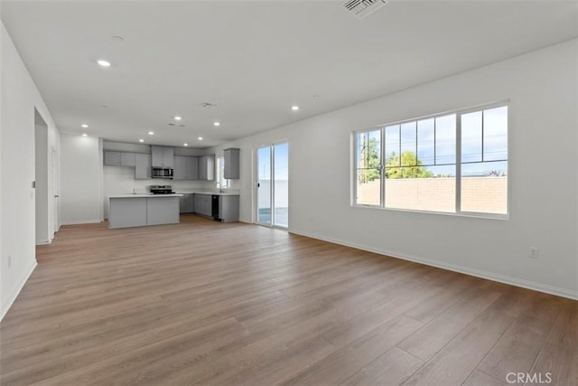 unfurnished living room with light hardwood / wood-style floors and sink