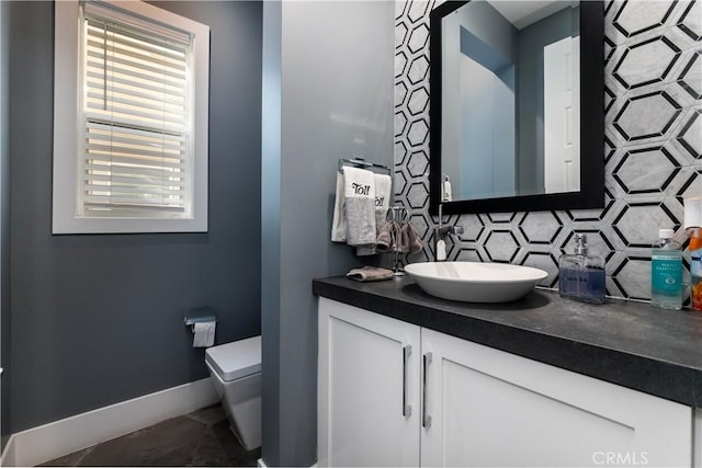 bathroom with tasteful backsplash, vanity, and toilet