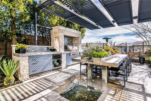 view of patio / terrace featuring area for grilling, wine cooler, an outdoor bar, and an outdoor stone fireplace