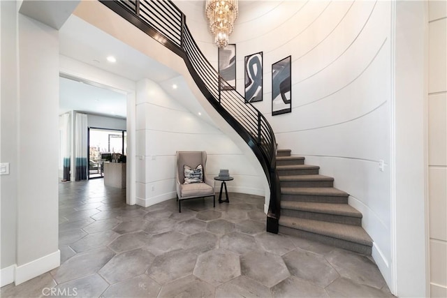 stairs featuring a chandelier