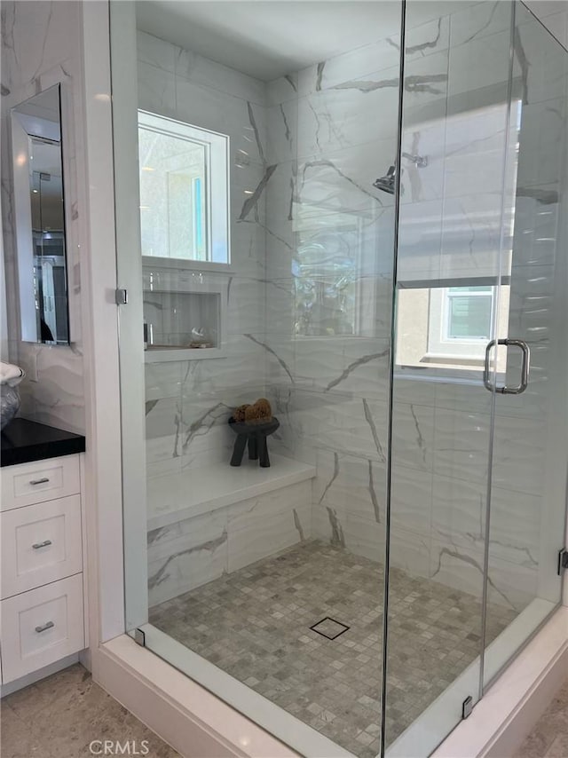 bathroom with vanity, a healthy amount of sunlight, and walk in shower