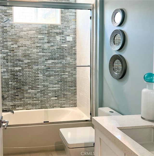 full bathroom with vanity, toilet, and bath / shower combo with glass door