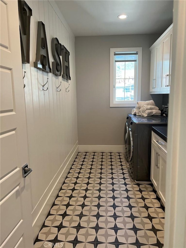 clothes washing area with cabinets and independent washer and dryer