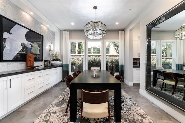 dining area featuring an inviting chandelier, plenty of natural light, and ornamental molding