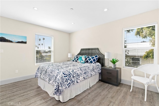 bedroom featuring multiple windows and light hardwood / wood-style flooring