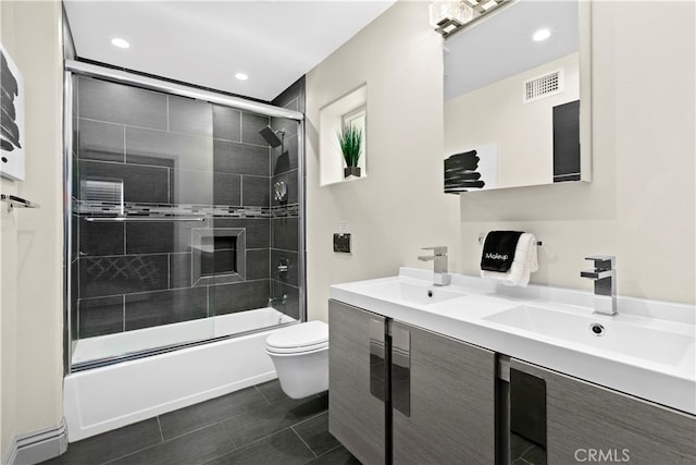 full bathroom with enclosed tub / shower combo, vanity, and toilet