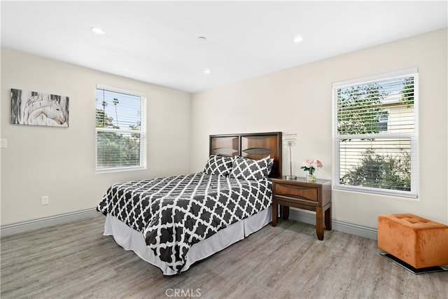 bedroom with light wood-type flooring and multiple windows