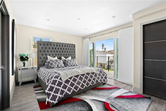 bedroom featuring access to outside and light hardwood / wood-style floors