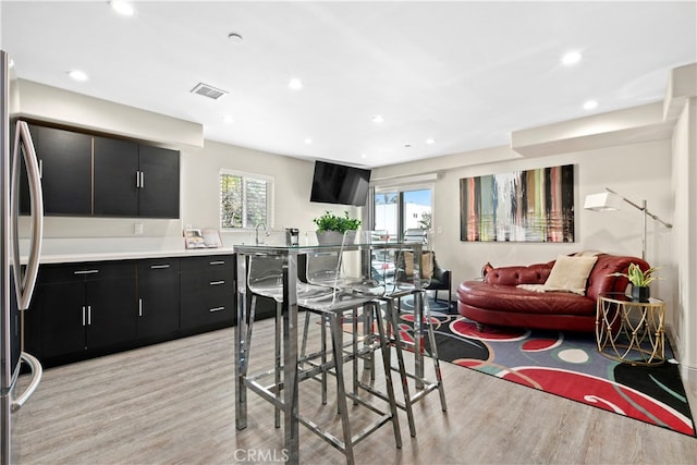 kitchen featuring stainless steel refrigerator and light hardwood / wood-style floors