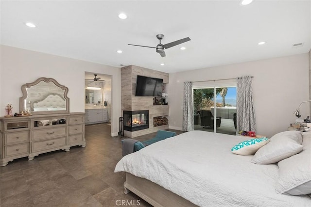 bedroom featuring access to exterior, a large fireplace, ensuite bathroom, and ceiling fan