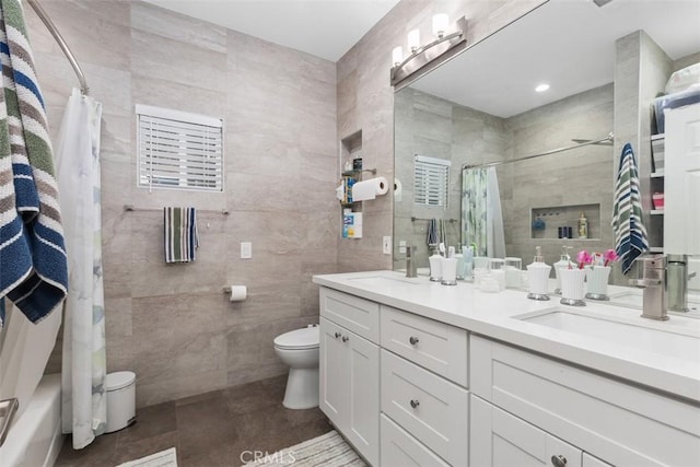 full bathroom featuring tile patterned floors, toilet, shower / tub combo with curtain, vanity, and tile walls