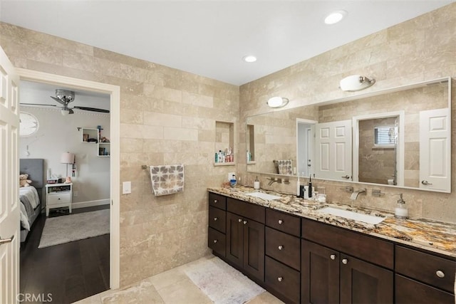 bathroom featuring vanity, ceiling fan, wood-type flooring, and tile walls