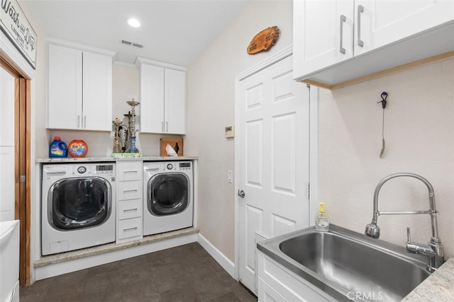 laundry area with cabinets, independent washer and dryer, and sink