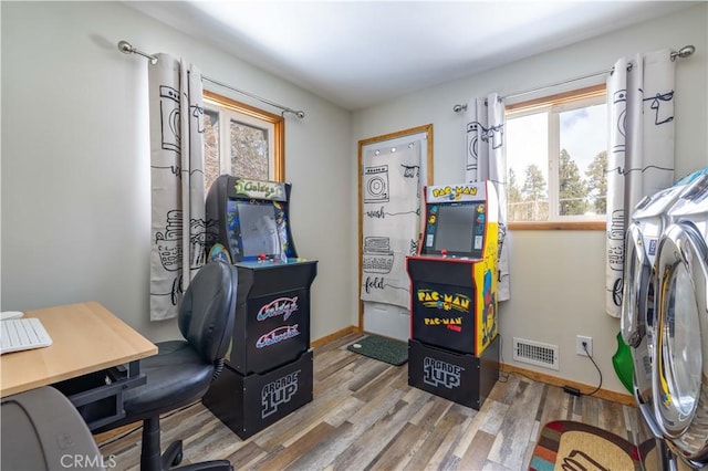 office with light wood-type flooring and washer and clothes dryer