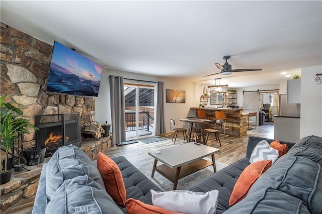 living room featuring a barn door, hardwood / wood-style floors, a healthy amount of sunlight, and a fireplace