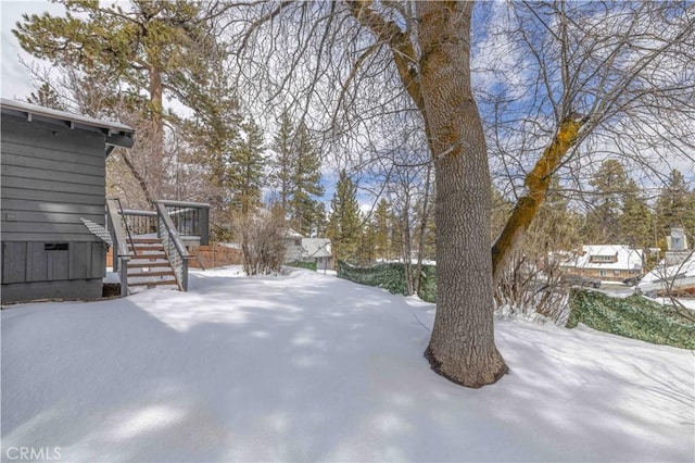 yard layered in snow featuring a deck