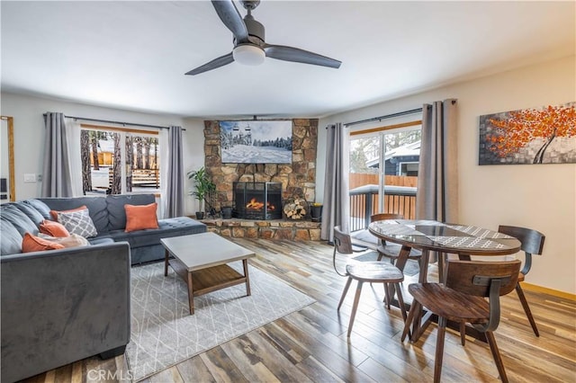 living room with hardwood / wood-style flooring, ceiling fan, and a fireplace