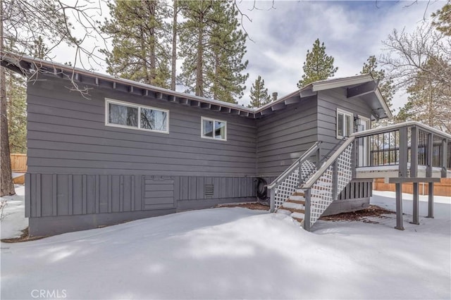 snow covered property with a wooden deck