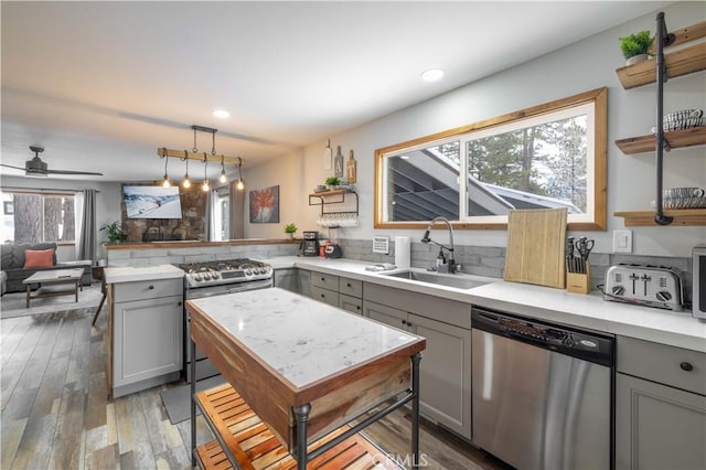 kitchen featuring ceiling fan, sink, pendant lighting, gray cabinets, and appliances with stainless steel finishes