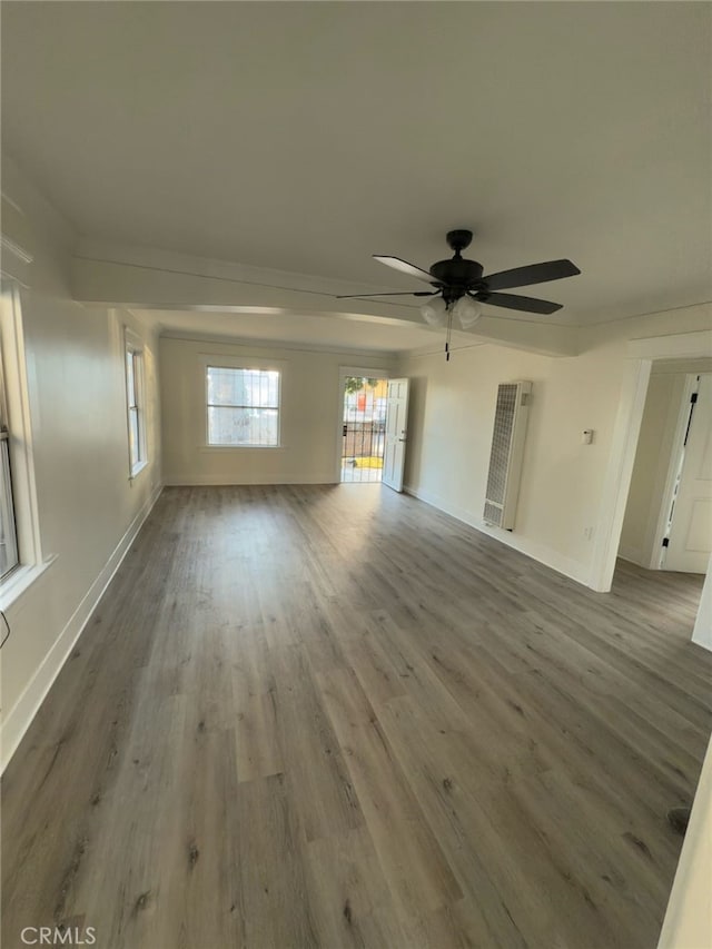 unfurnished living room with baseboards, wood finished floors, and a ceiling fan