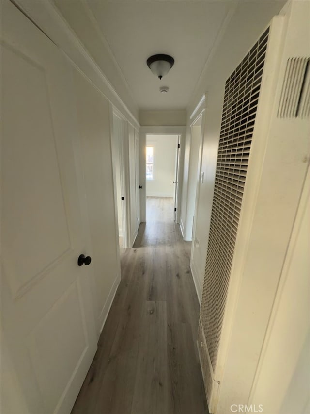 corridor with a heating unit and wood finished floors