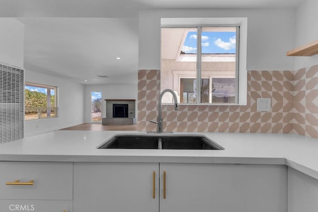 kitchen featuring white cabinetry, sink, and backsplash