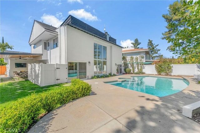 back of house featuring a patio, a fenced in pool, ceiling fan, and a lawn