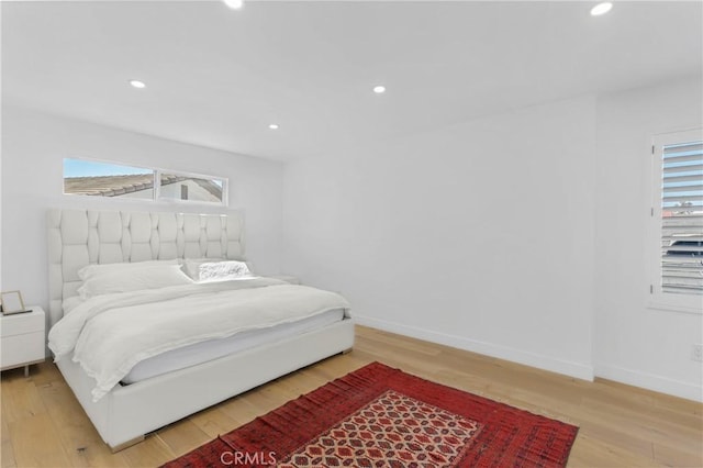 bedroom with wood-type flooring and multiple windows