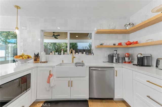 kitchen with white cabinetry, dishwasher, black microwave, sink, and decorative backsplash