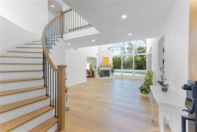 staircase featuring hardwood / wood-style flooring and a notable chandelier