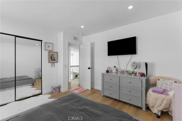 bedroom with light hardwood / wood-style flooring and a closet