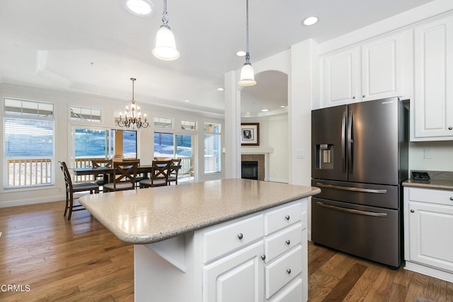 kitchen with white cabinetry, a tile fireplace, a kitchen island, dark hardwood / wood-style flooring, and stainless steel refrigerator with ice dispenser