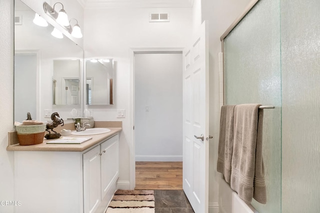 bathroom with wood-type flooring, vanity, and ornamental molding