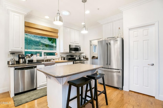 kitchen featuring light hardwood / wood-style flooring, stainless steel appliances, white cabinetry, and a kitchen island