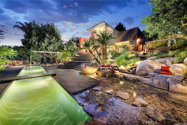 yard at dusk featuring a wooden deck