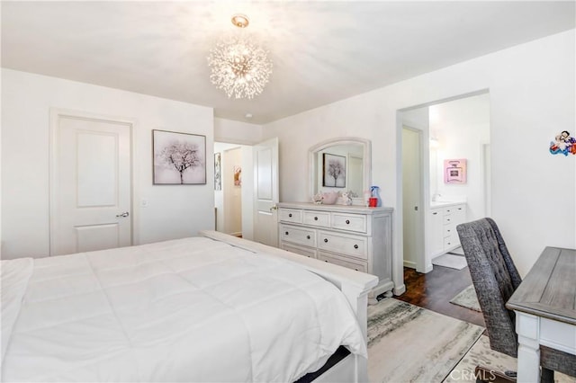 bedroom with ensuite bathroom, dark wood-type flooring, and an inviting chandelier