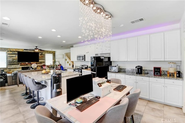 kitchen featuring an island with sink, white cabinets, and stainless steel appliances